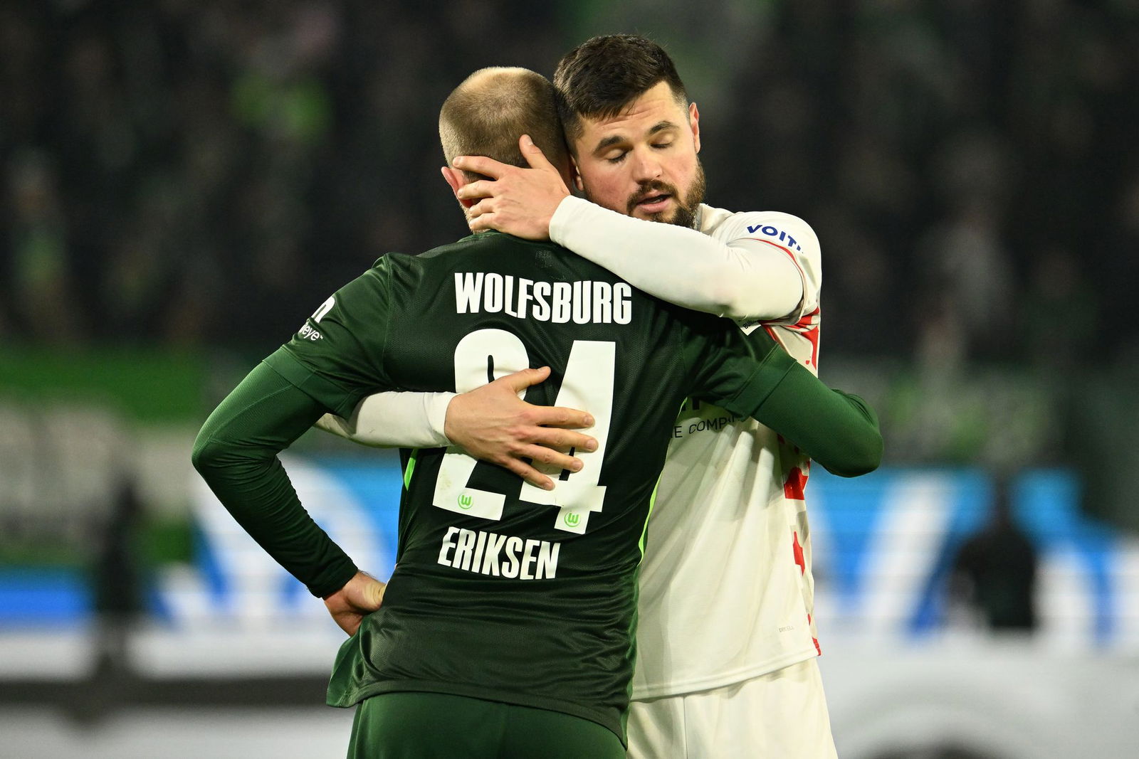 Heidenheims Marnon Busch umarmt Wolfsburg-Star Christian Eriksen.