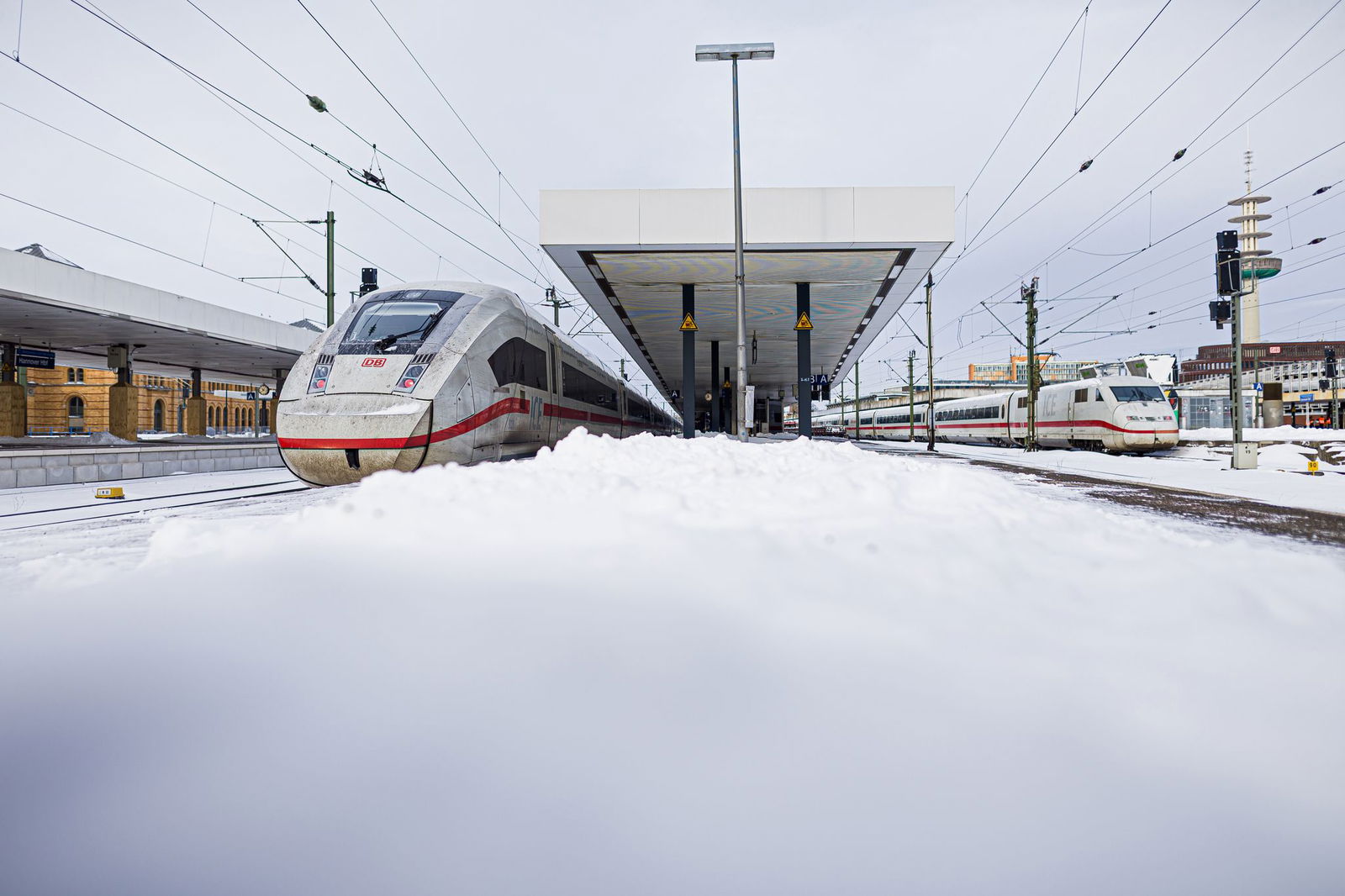 Zwei ICE stehen im verschneiten Hauptbahnhof Hannover.