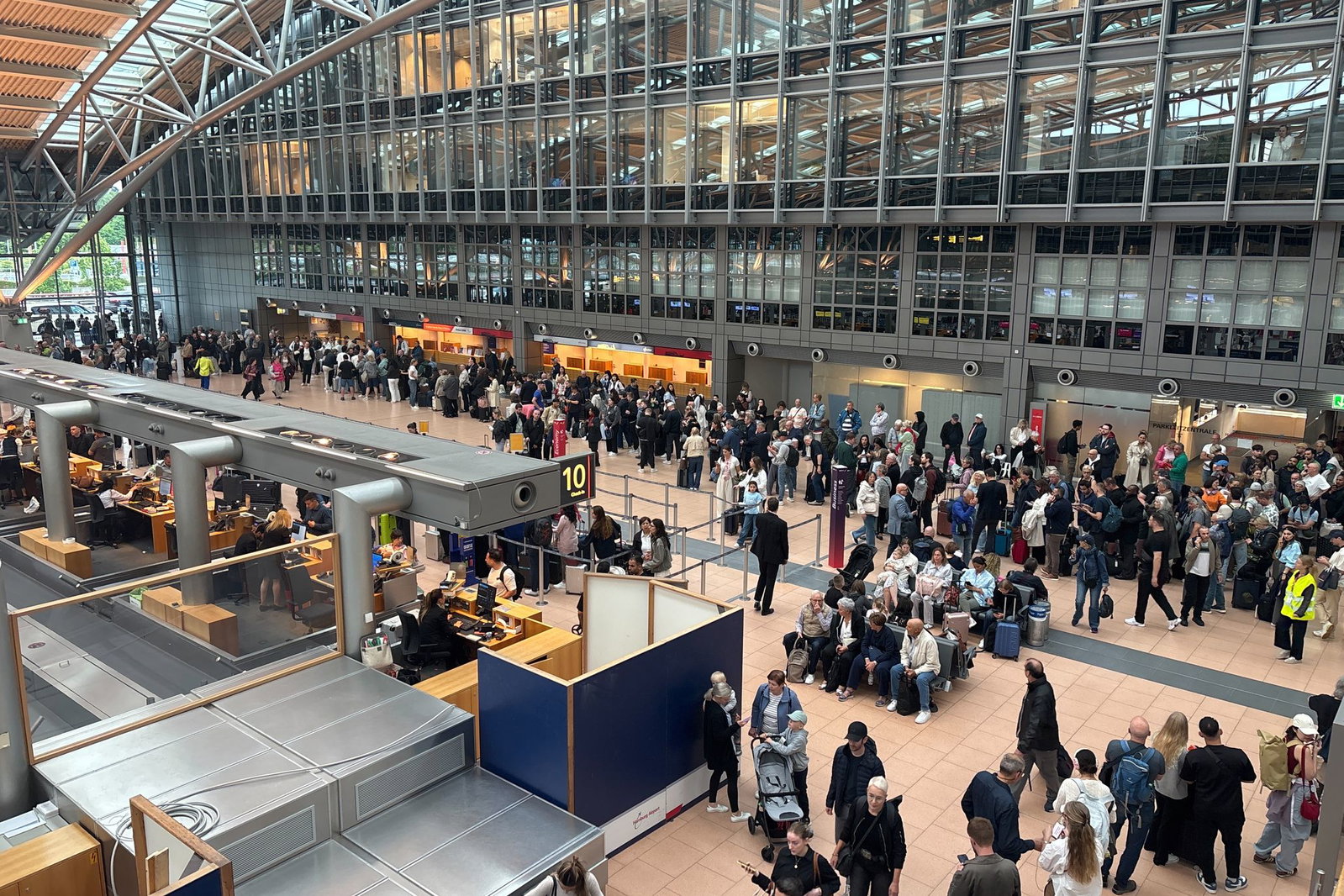 Zahlreiche Menschen stehen im Terminal des Hamburger Flughafens.