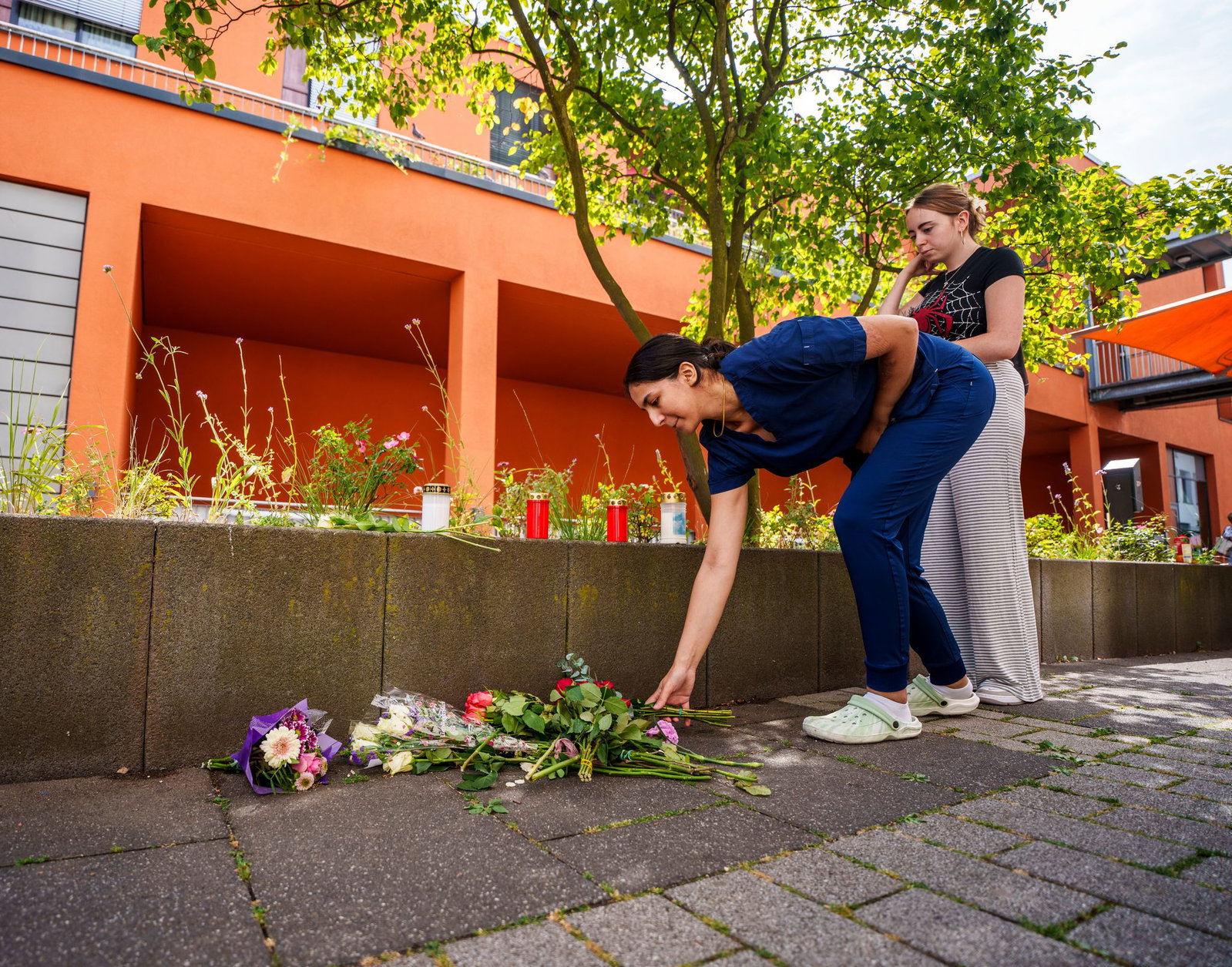 Menschen kommen vorbei und legen Blumen ab.