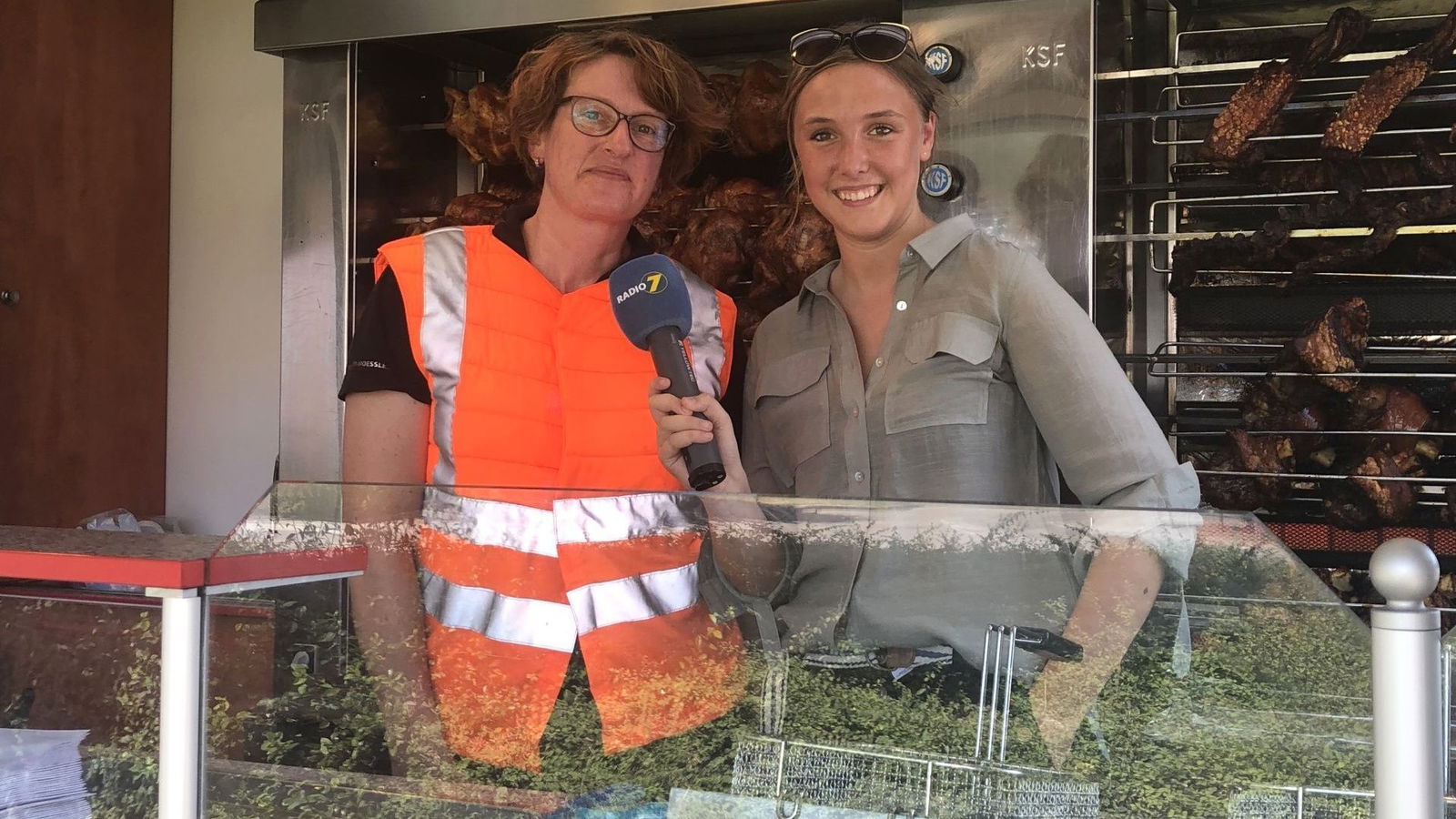 Steffi vom Hend’l und Hax’n Grill in Neu Ulm in Kühlweste mit Radio 7 Reporterin Anna Dworak